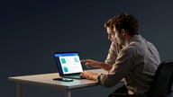 A small-business colleague using an AI assistant dashboard on a laptop