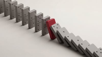 Domino cascade halted by a red block symbolising data resilience